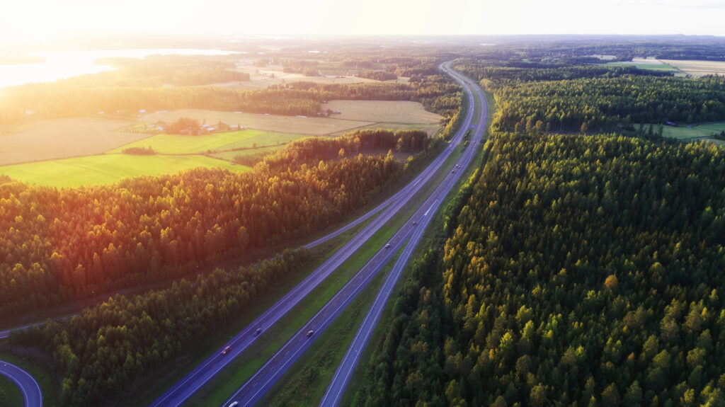 Moottoritie ilmasta kuvattuna. Taustalla auringonlasku.